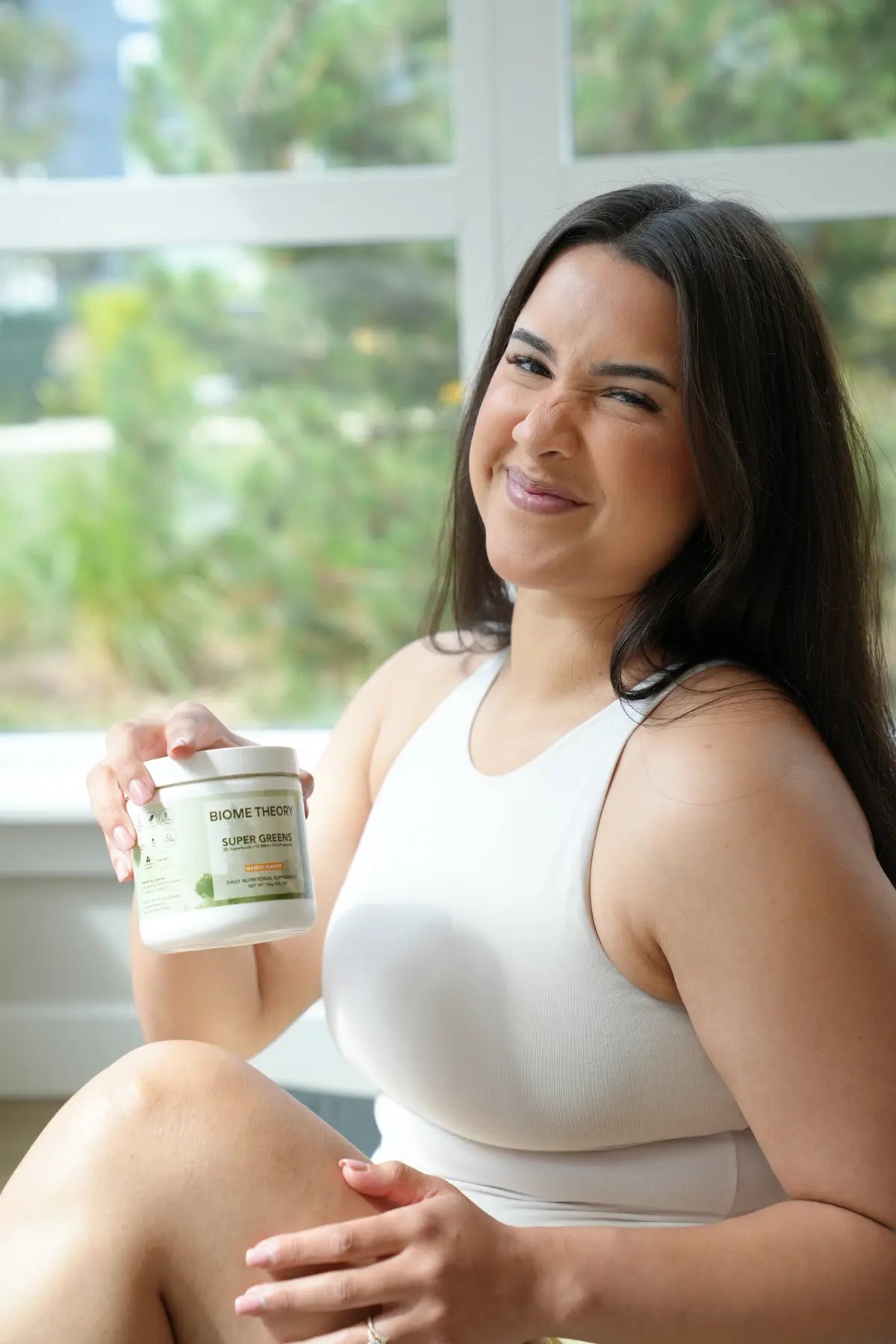 Woman smiling and holding Biome Theory Super Greens